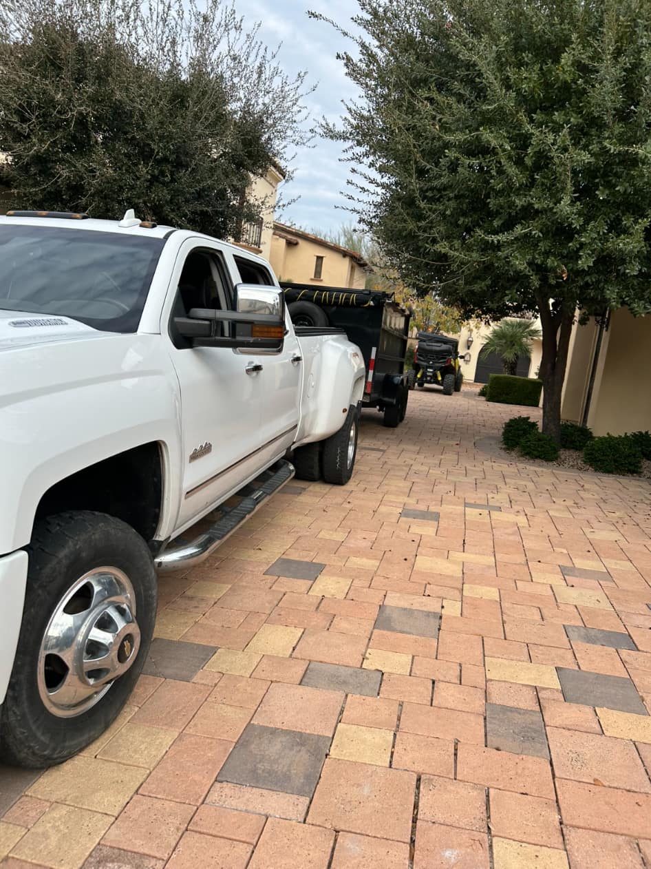 AZ Junk Pros truck and empty trailer at a residential property