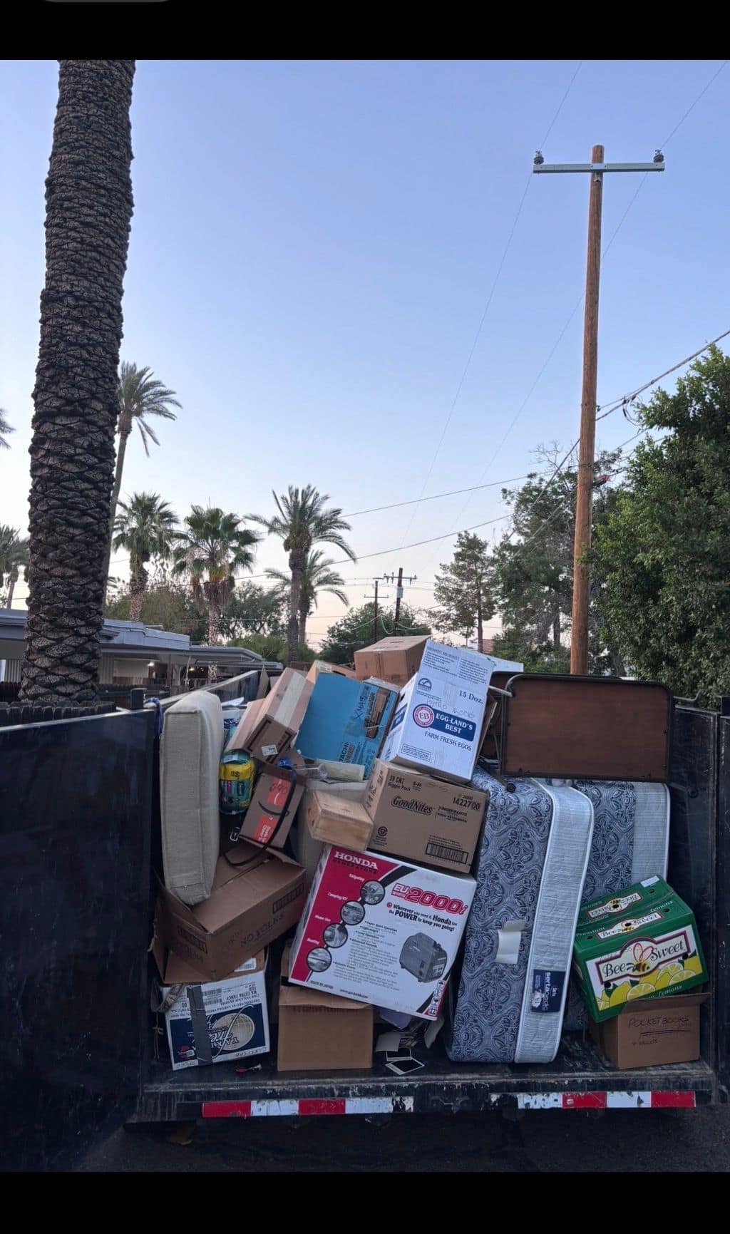 Trailer loaded with household items and a mattress from a house cleanout