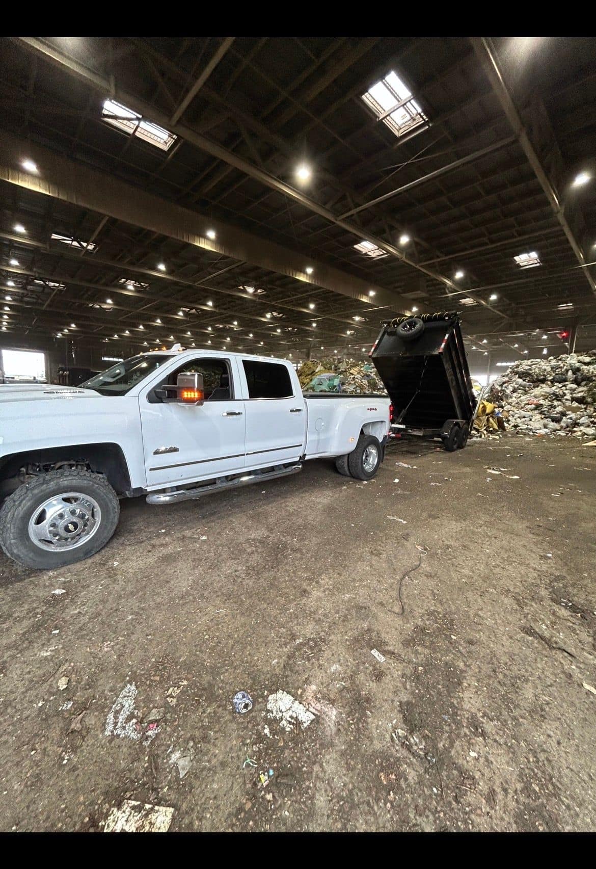Dump trailer raised and unloading at a disposal facility
