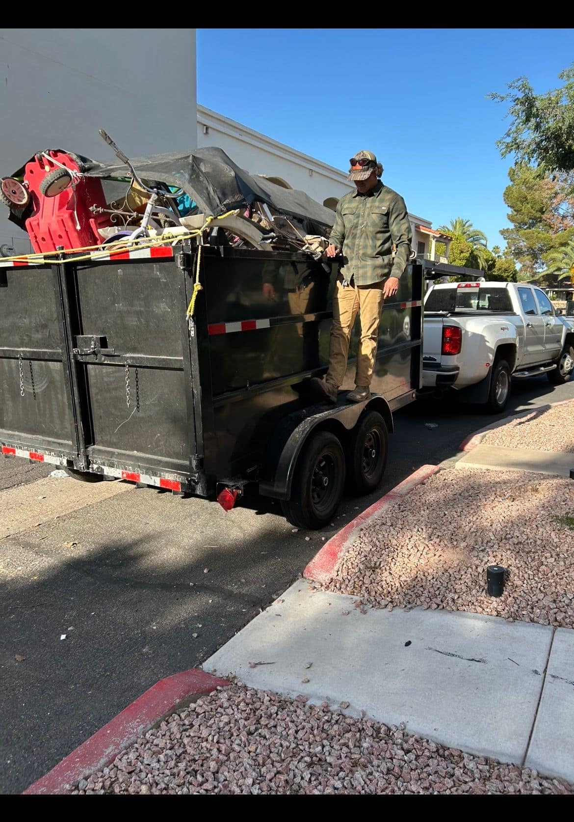 AZ Junk Pros crew member on a fully loaded dump trailer