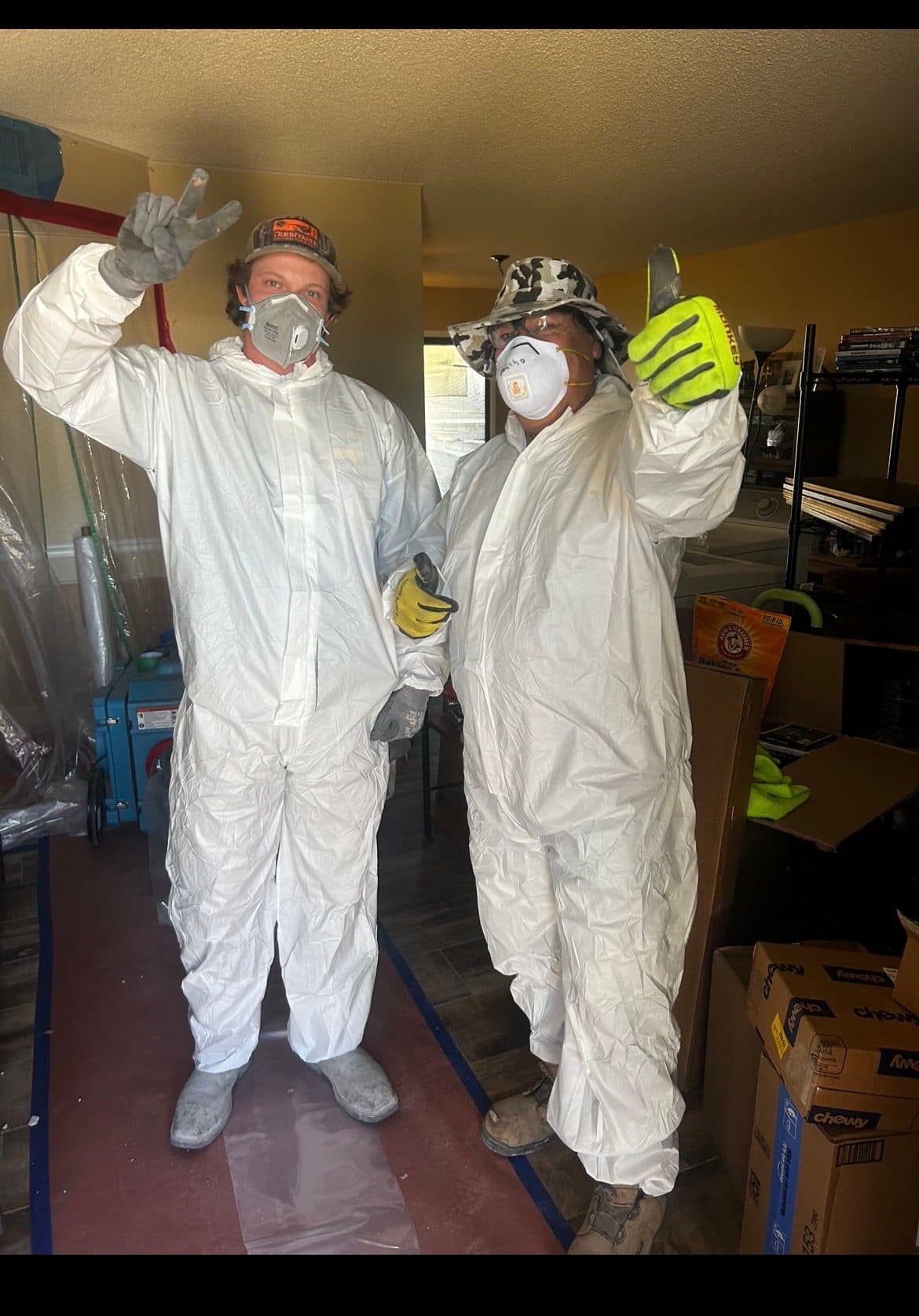 Two crew members in protective suits and respirators
